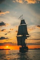 silhouette of ship on sea during sunset