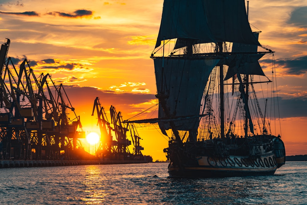 silhouette of ship on sea during sunset