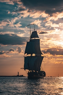 silhouette of ship on sea during sunset