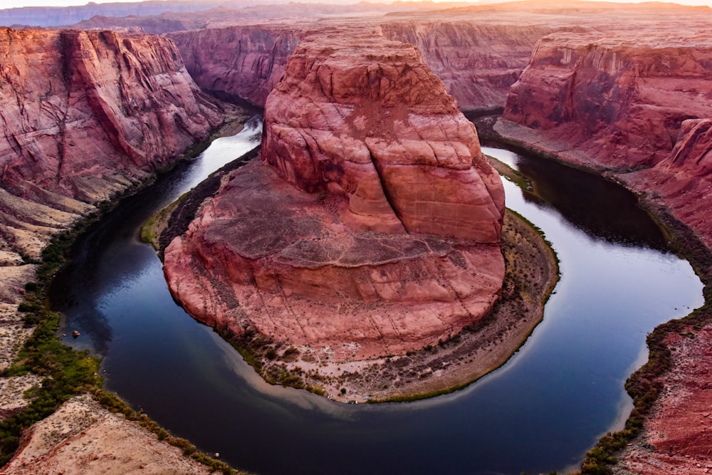 brown rock formation on body of water during daytime