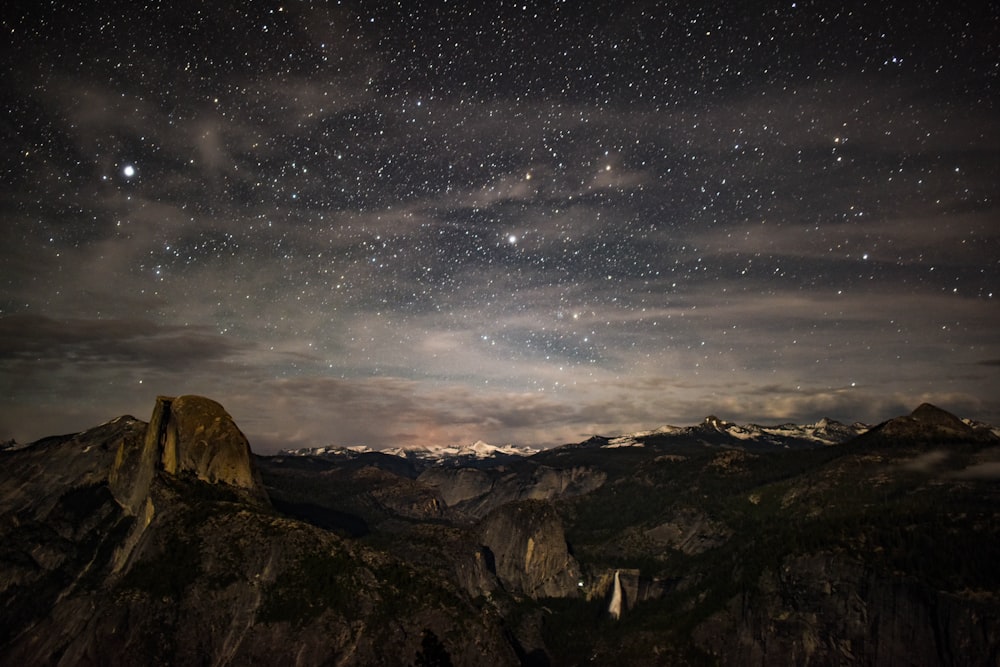 brown rock formation under starry night