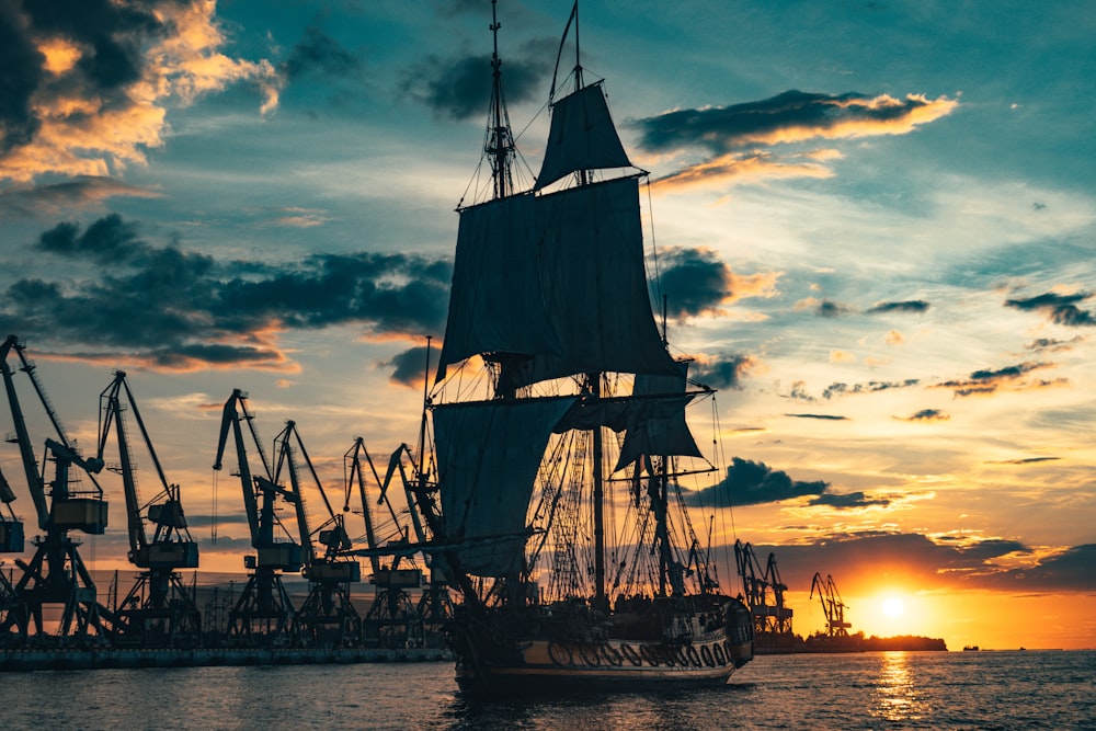 silhouette of ship on sea during sunset