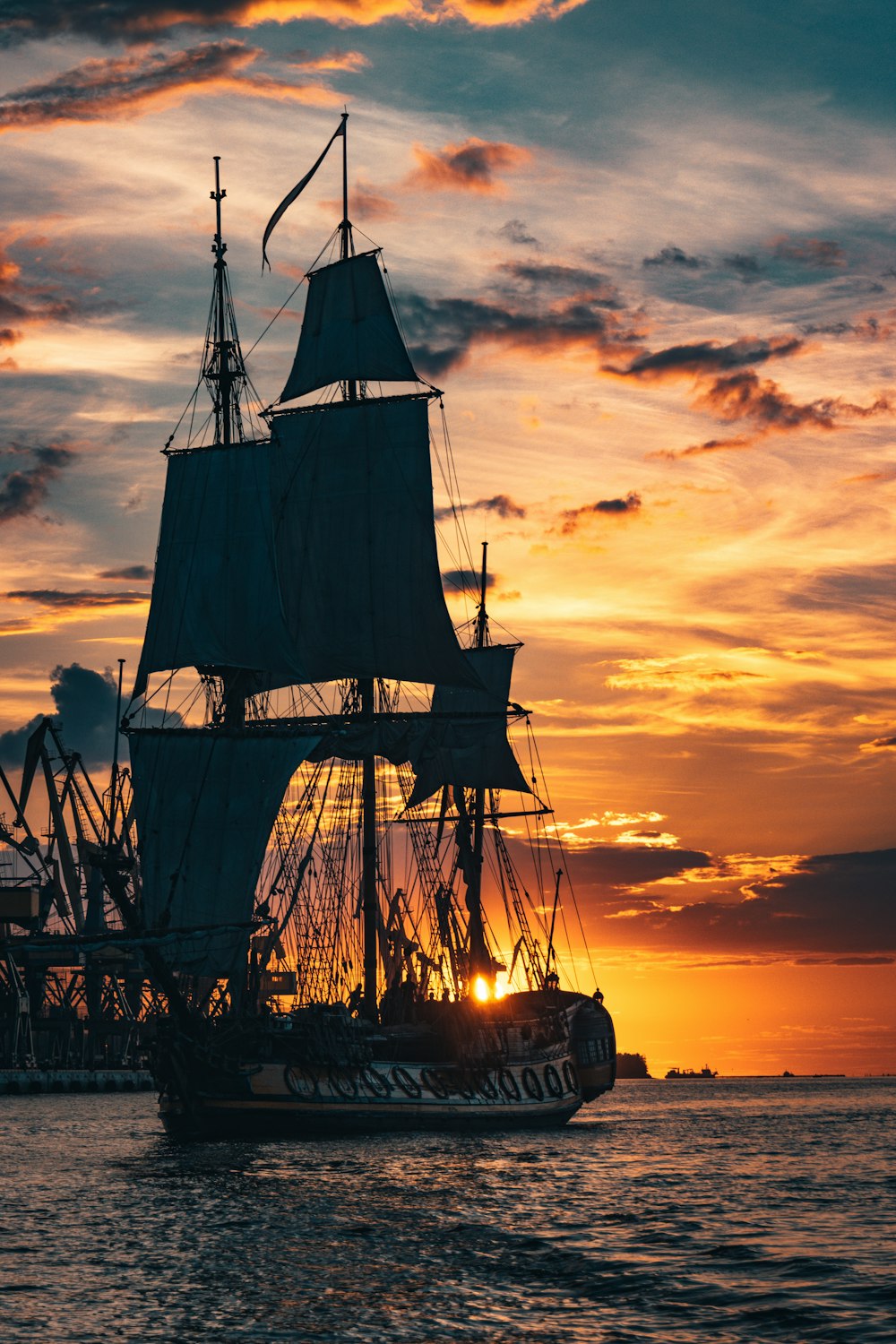 silhouette of ship on sea during sunset