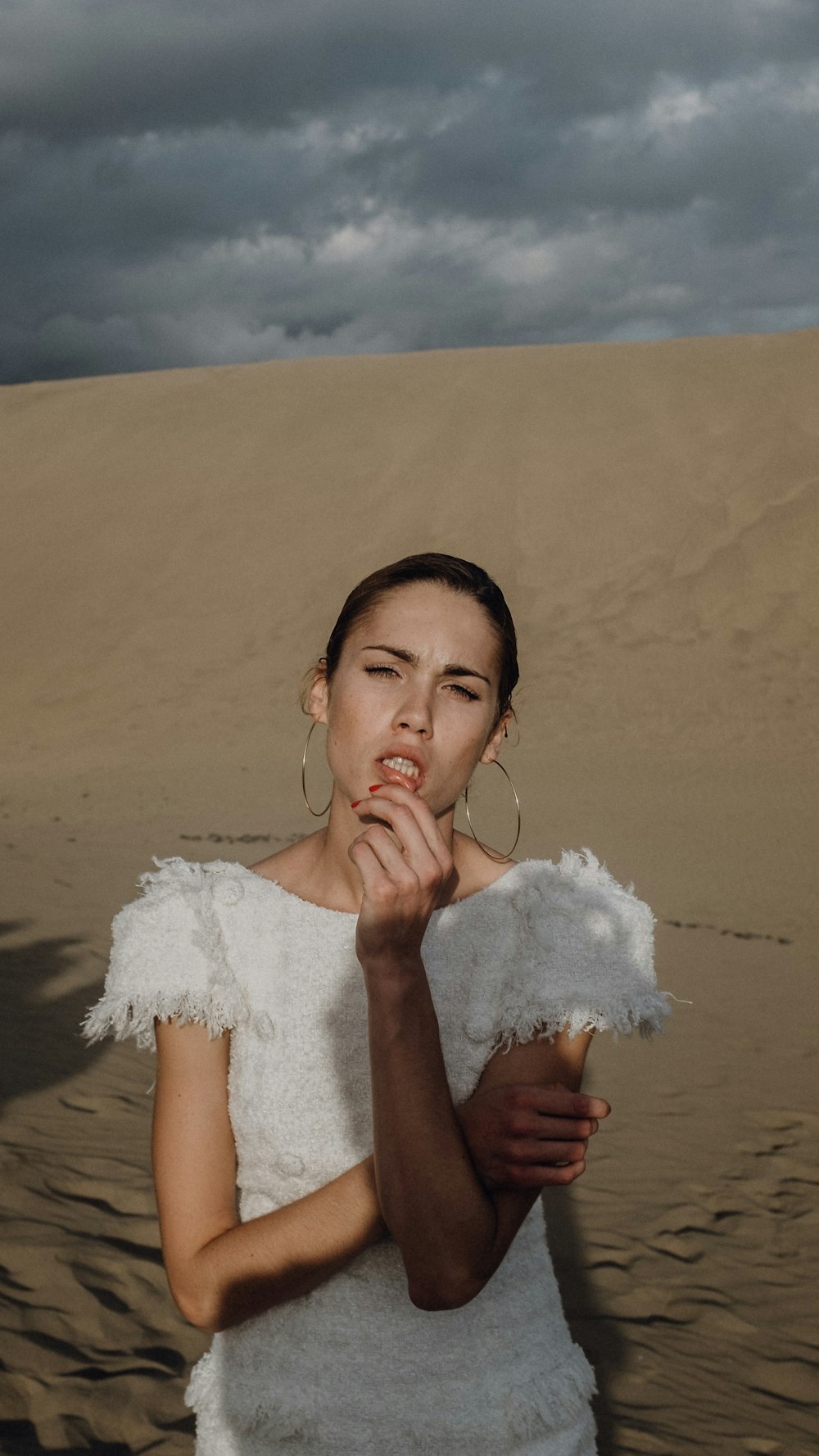 girl in white lace dress standing on sand