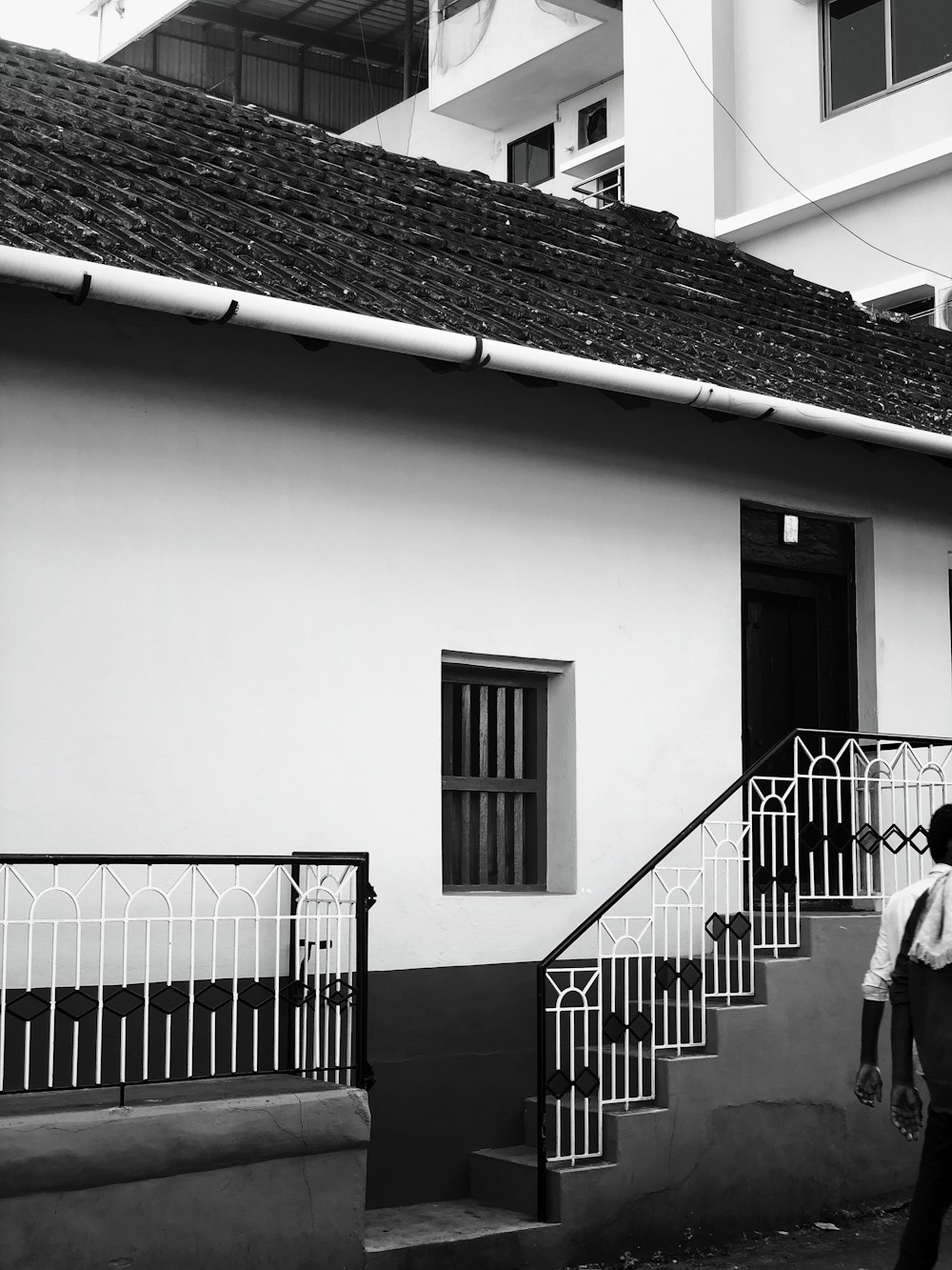 grayscale photo of man walking on stairs