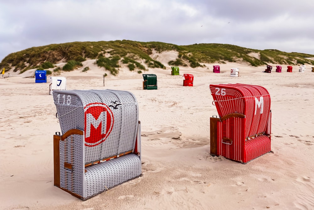 red and white coca cola cooler on white sand during daytime