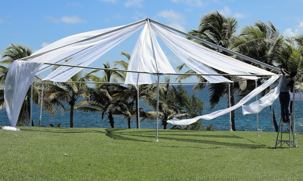 tenda a baldacchino bianca sul campo di erba verde durante il giorno