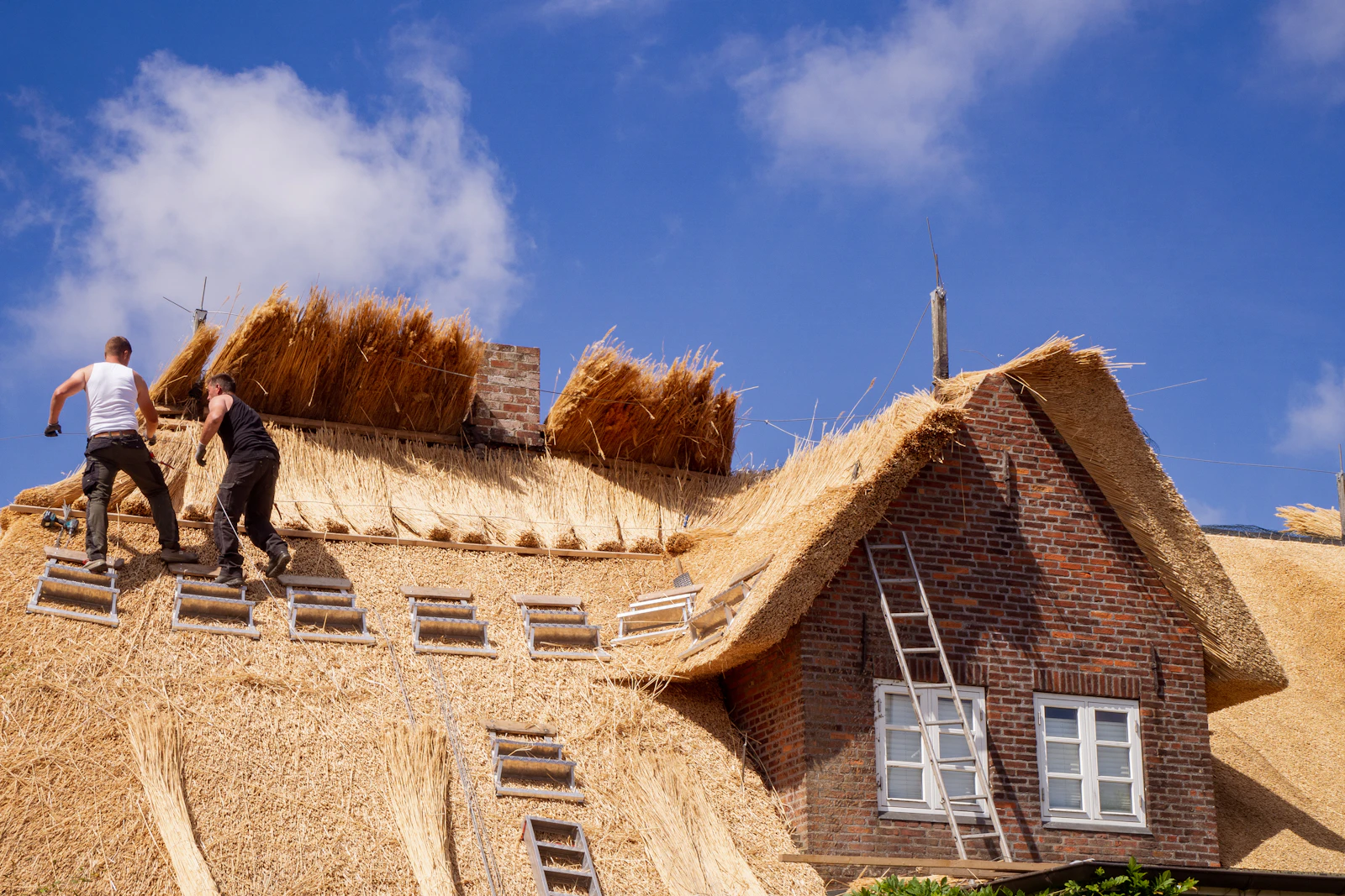 Experienced roofer fastening shingles by hand the traditional way