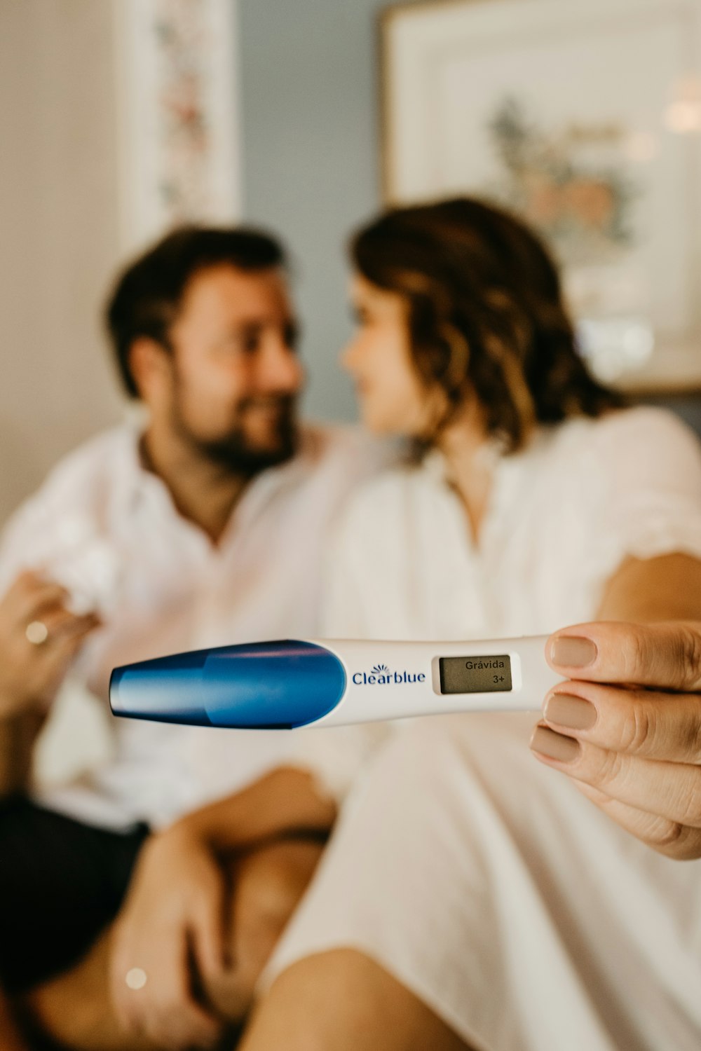 Mann in weißem Hemd mit blau-weißem Digitalthermometer