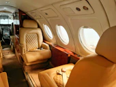 Tan leather seats with quilted stitching inside a private jet cabin