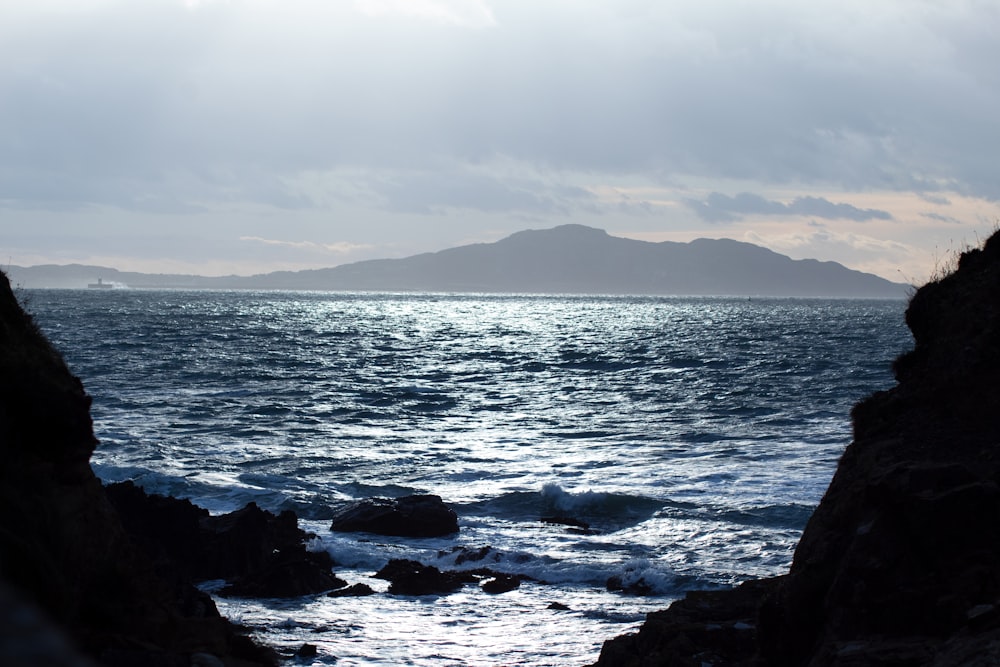 black rocks on sea shore during daytime