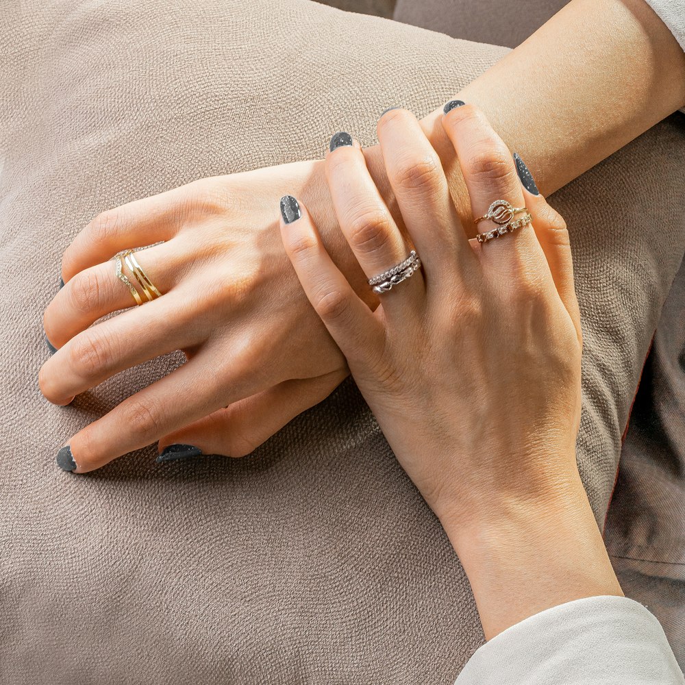 person wearing silver ring and gold ring