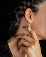 Close-up of handcrafted jewelry combining natural materials and futuristic design, worn by a confident young creator.