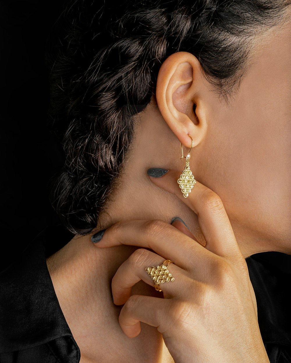 Mujer con anillo de diamantes dorados y camisa negra