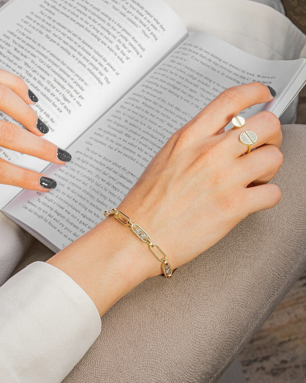 person wearing silver ring and white manicure