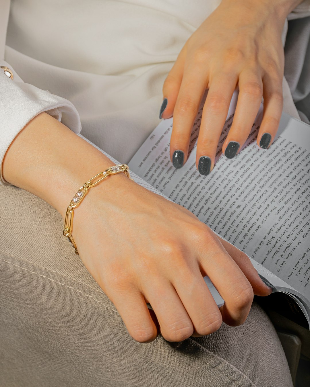 person wearing gold bracelet and white long sleeve shirt