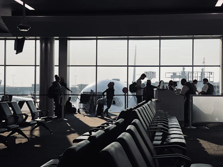 Illustration of a professional airport ground services team assisting passengers at check-in and boarding gates.