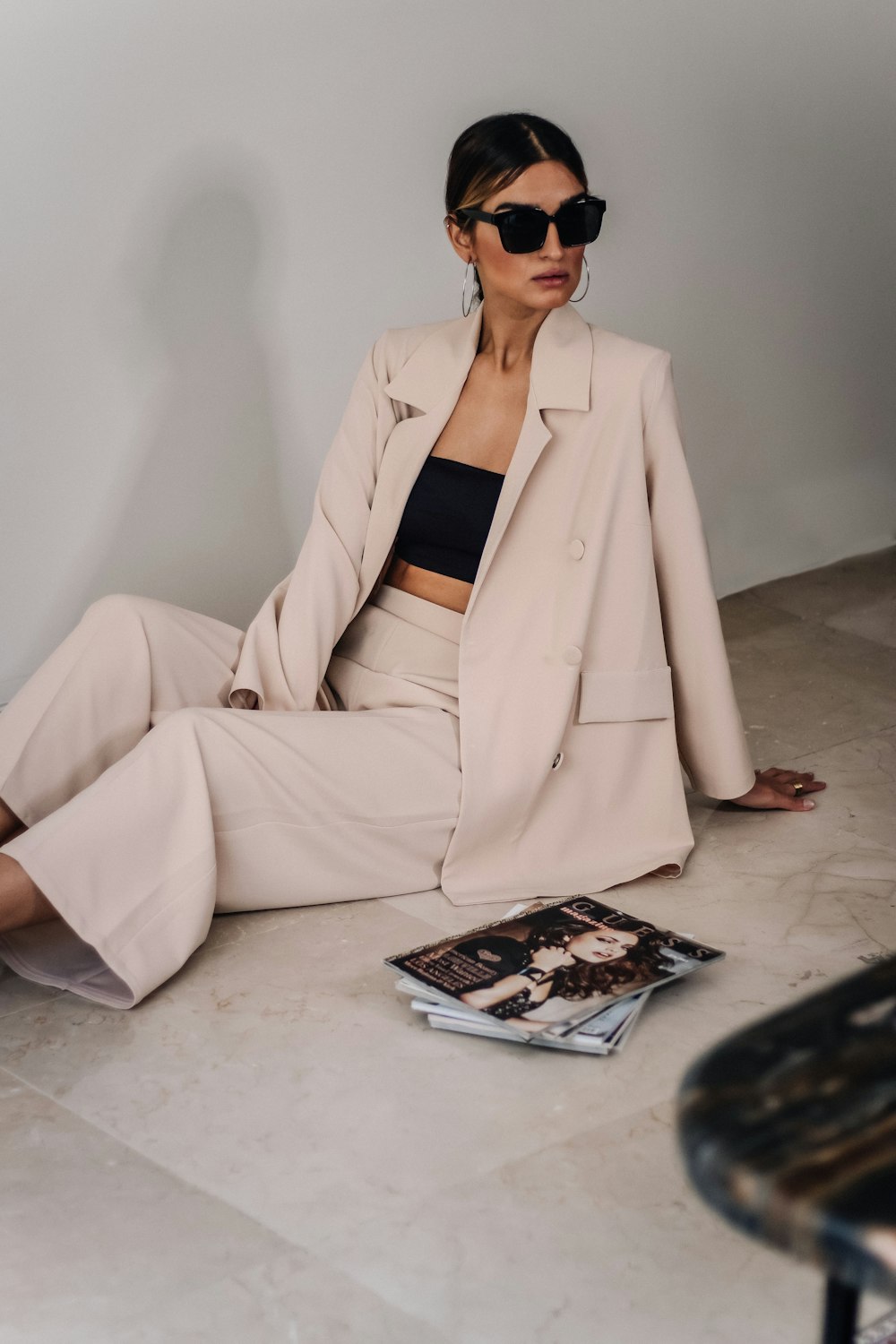 woman in beige blazer sitting on white table