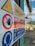 A close-up of a safety sign with warnings and instructions, including 'Limite di sicurezza' and 'Vietato l'accesso ai non addetti'. The sign features symbols such as a hand indicating 'no access' and an icon of headphones with a message about hearing protection. The background shows an outdoor industrial setting.
