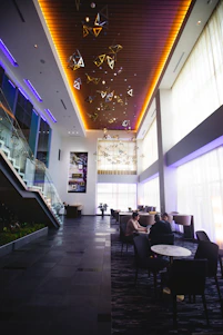 A friendly property manager discussing plans with condo residents in a bright, modern lobby.