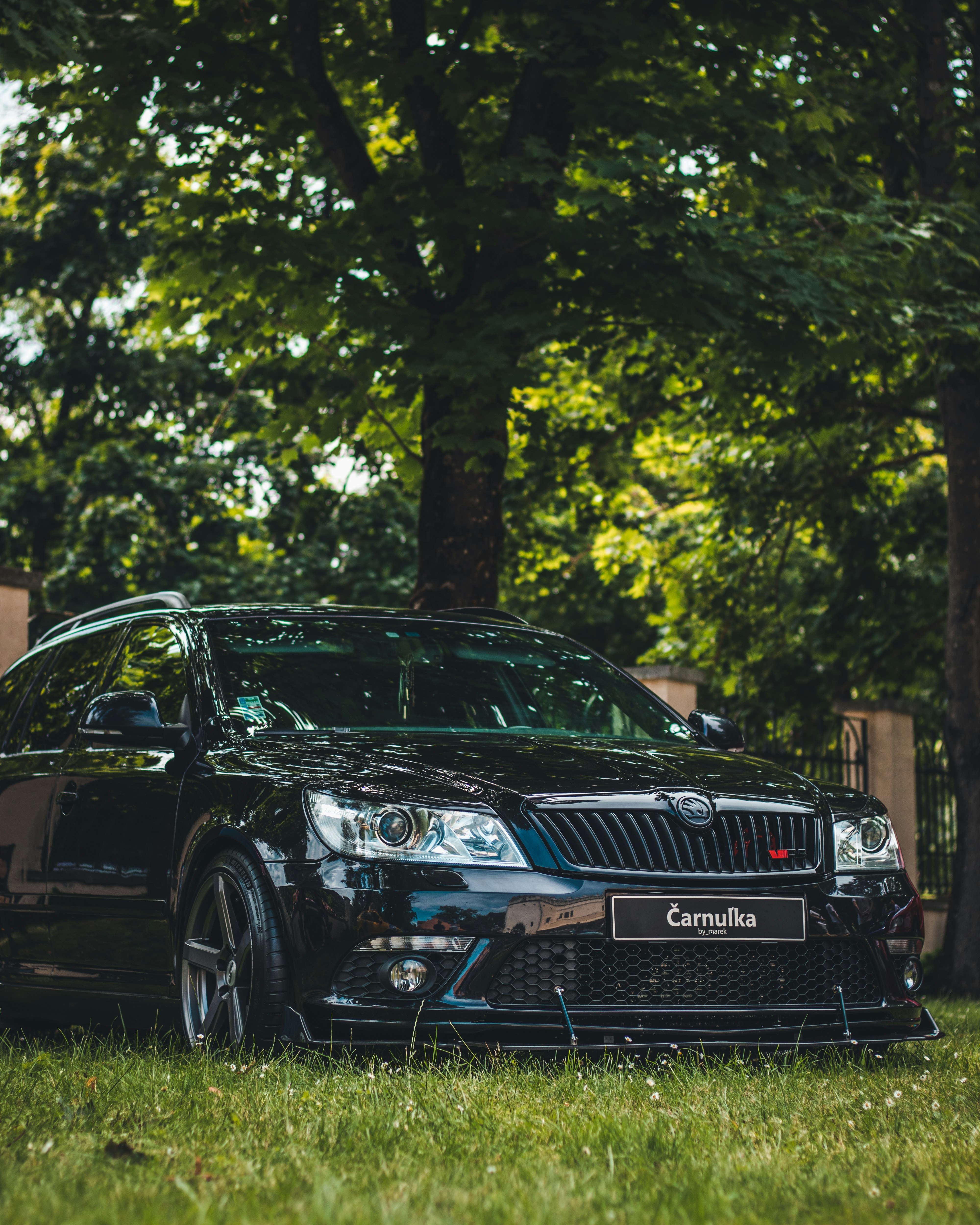 black bmw m 3 coupe parked on green grass field during daytime