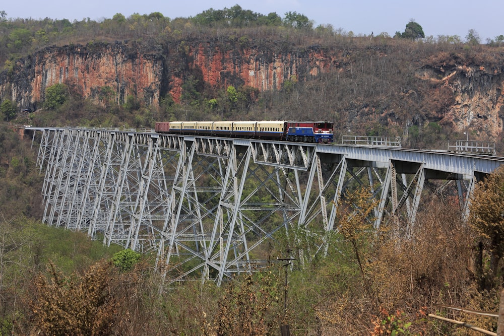 red and white train on rail bridge