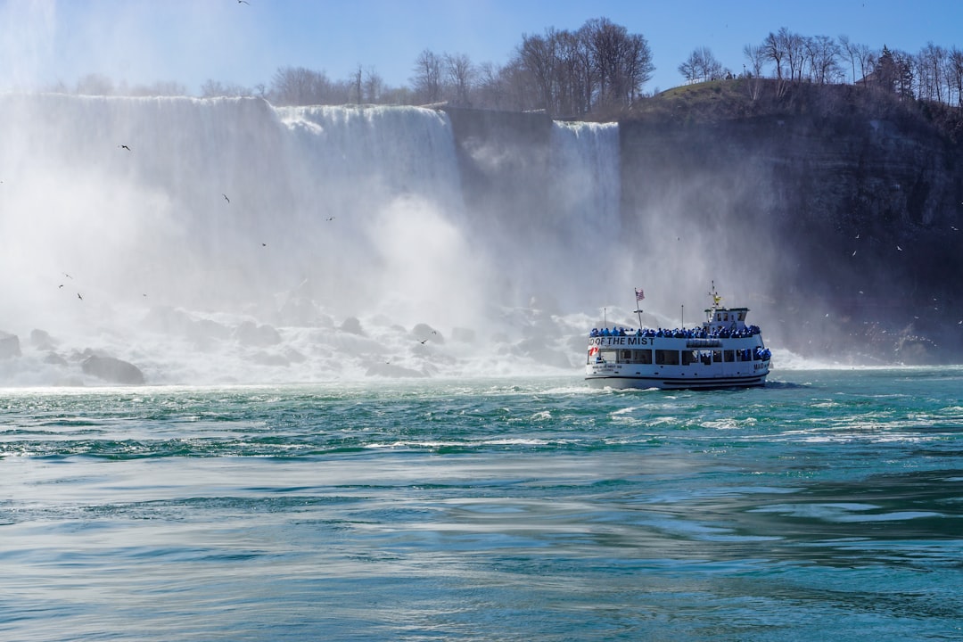 white and blue boat on water falls during daytime