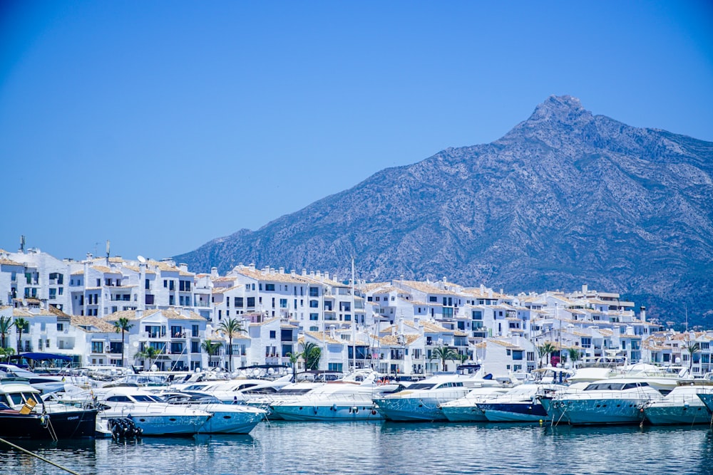 Bateaux blancs et bleus sur la mer près de la montagne sous le ciel bleu pendant la journée