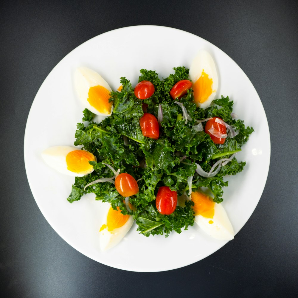 rodajas de tomate y verdura verde en plato de cerámica blanca