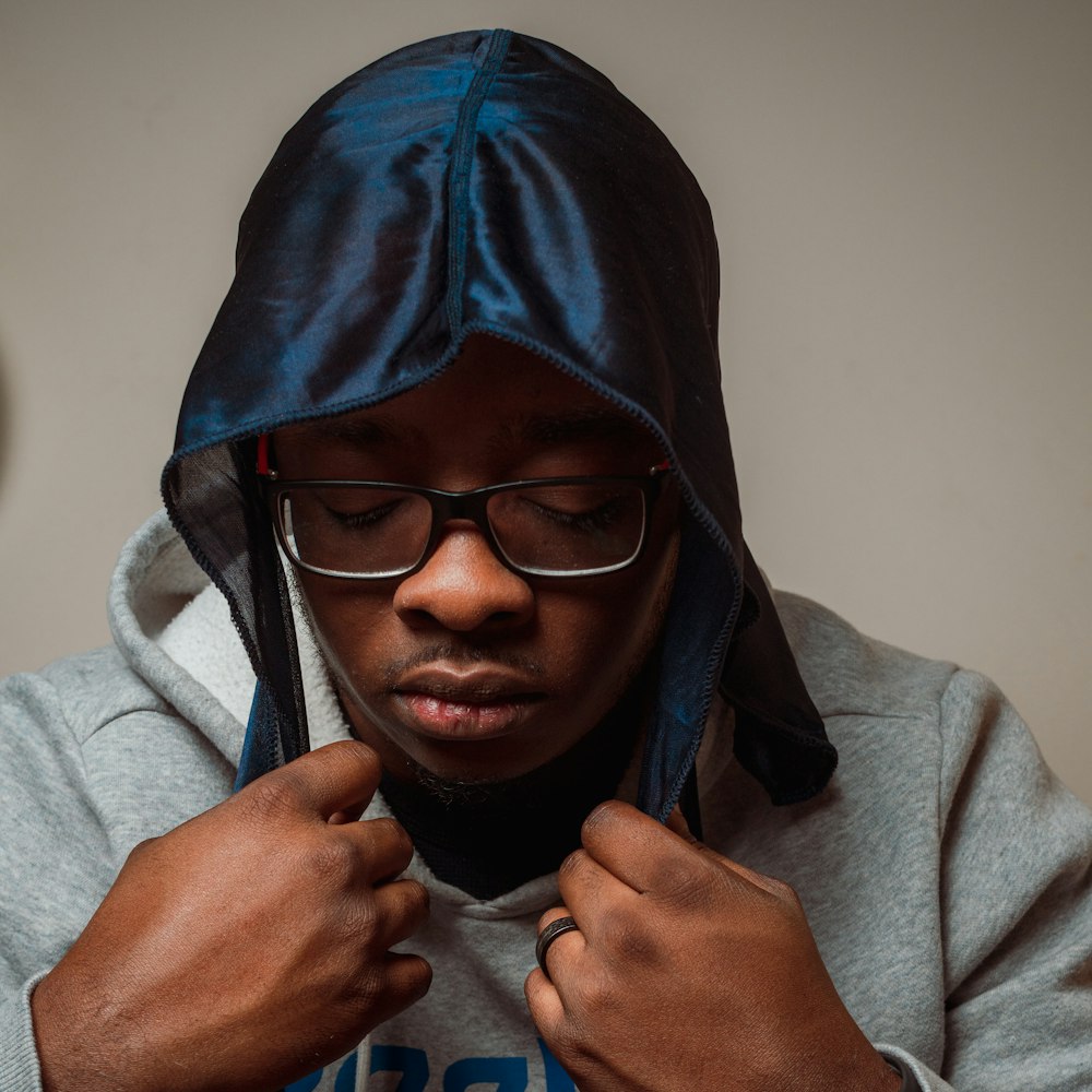 man in blue hoodie wearing black framed eyeglasses