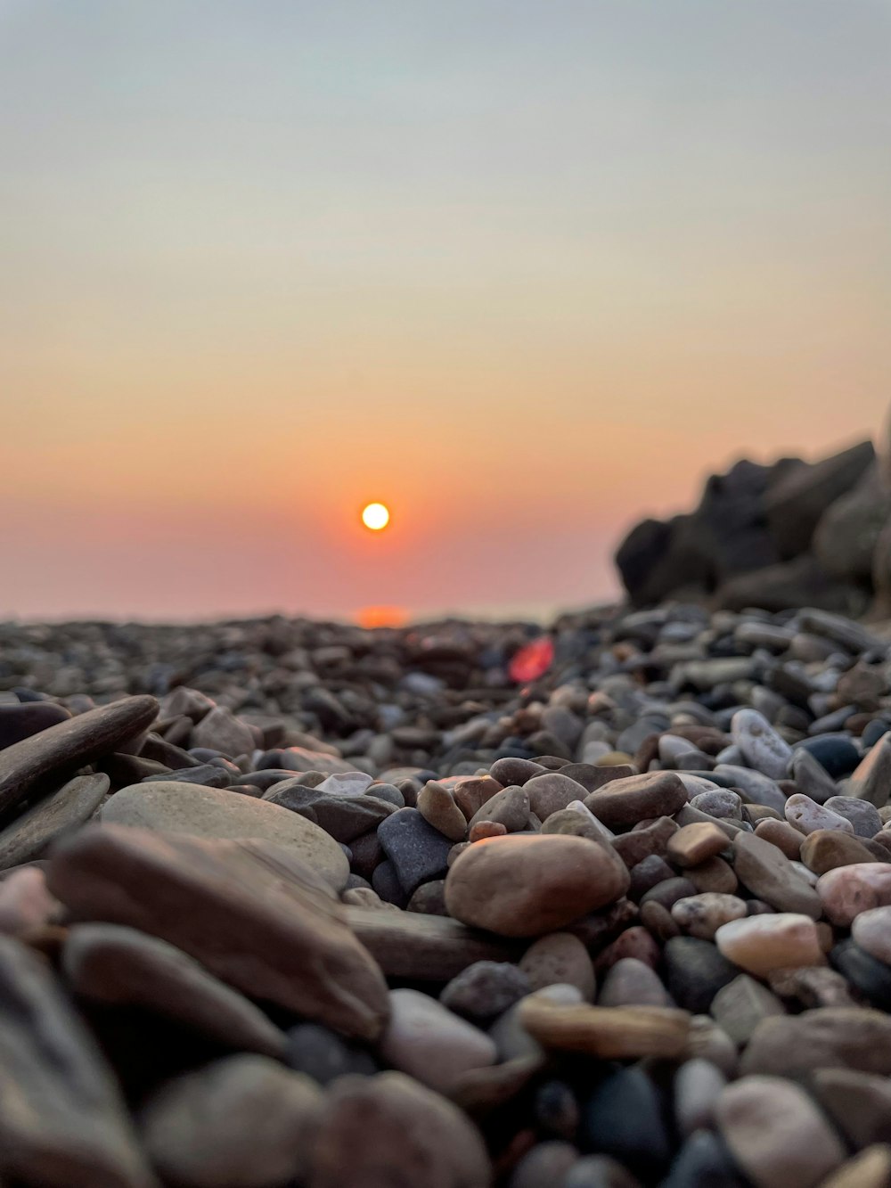 gray and black stones on beach during sunset