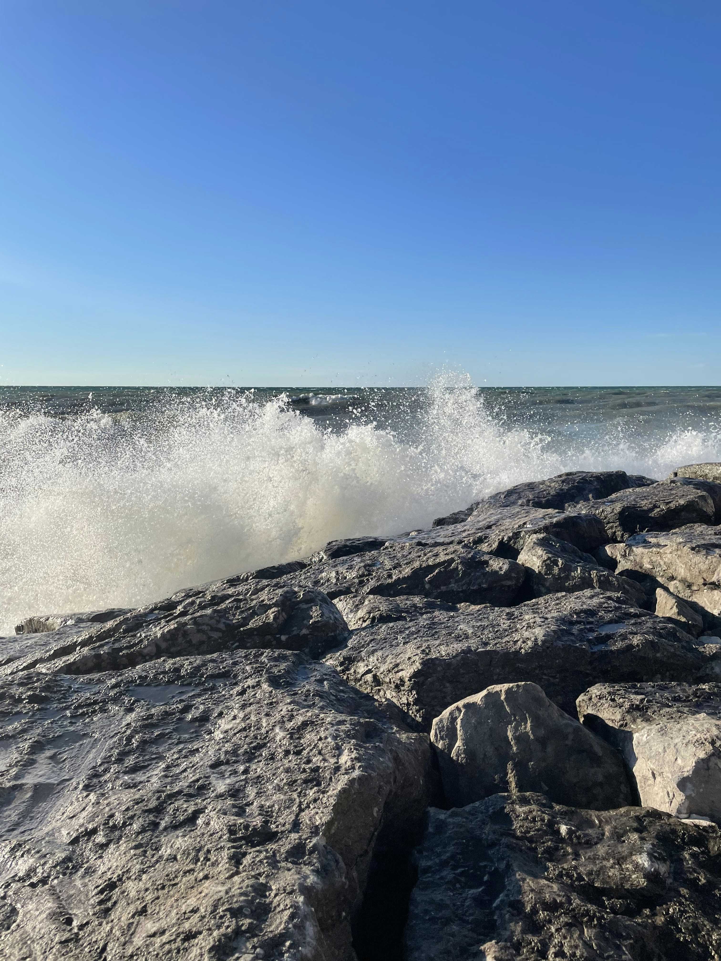ocean waves crashing on rocky shore during daytime