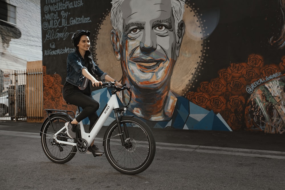 man in black jacket riding on blue bicycle