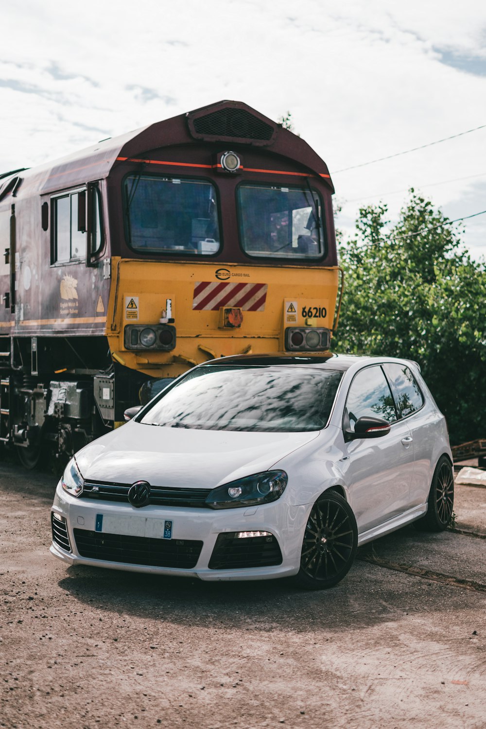 white bmw m 3 coupe parked beside yellow and black train during daytime