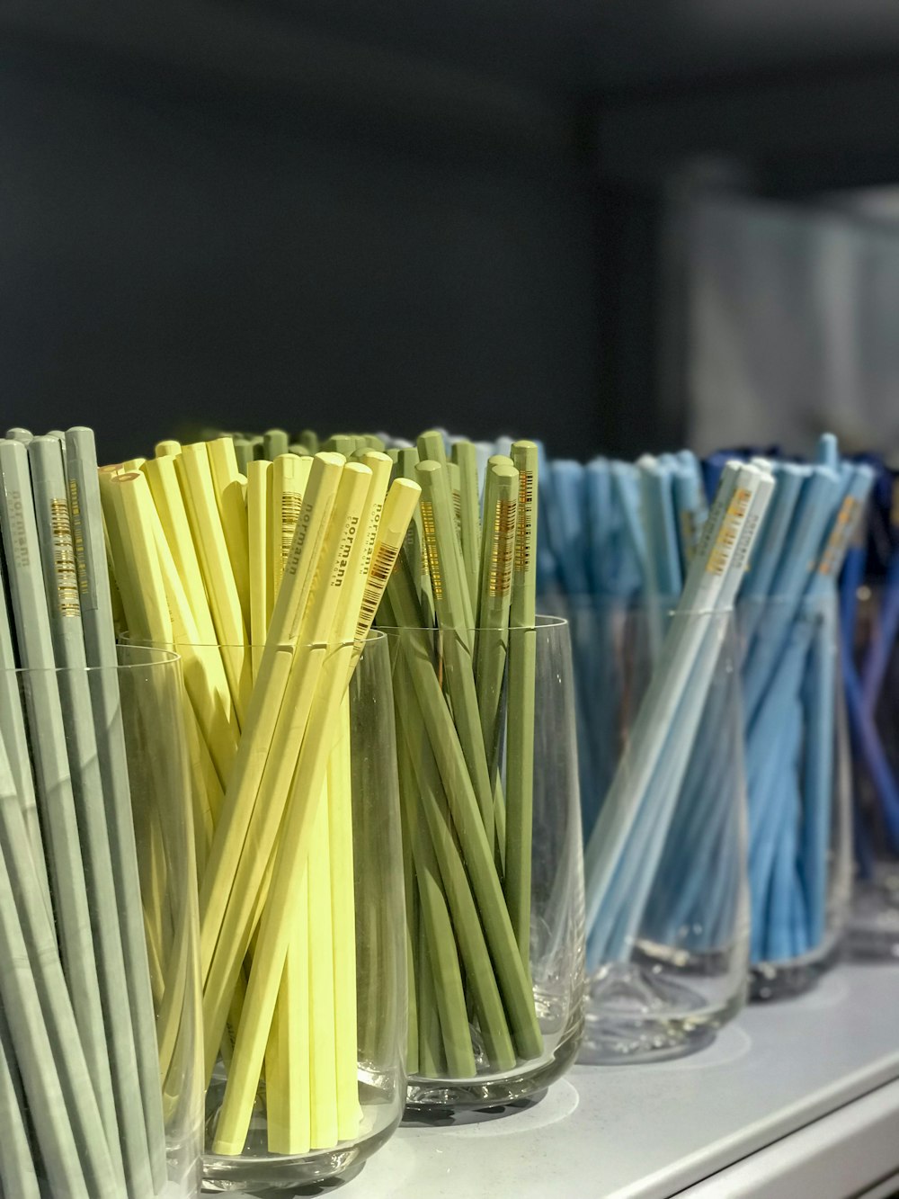 a row of different colored straws in a glass