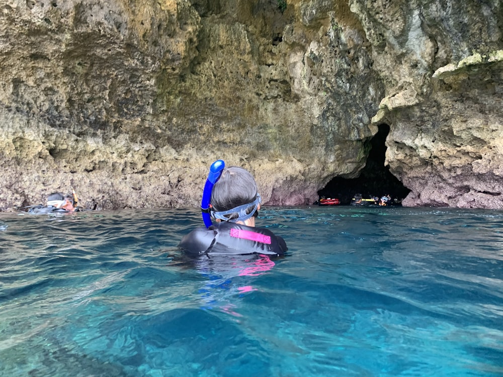 man in blue swimming goggles in blue water during daytime