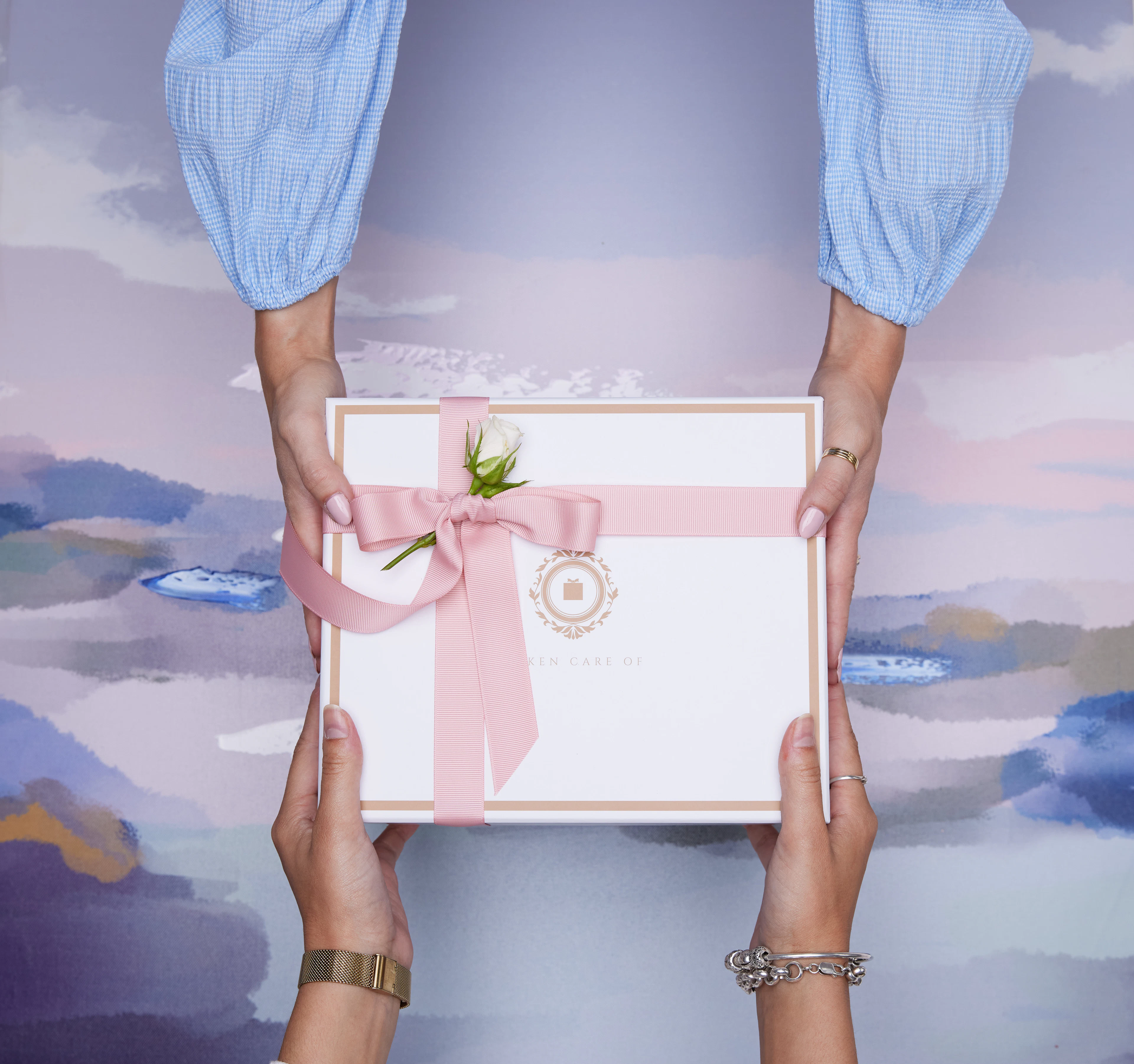 Two hands exchanging a wrapped gift