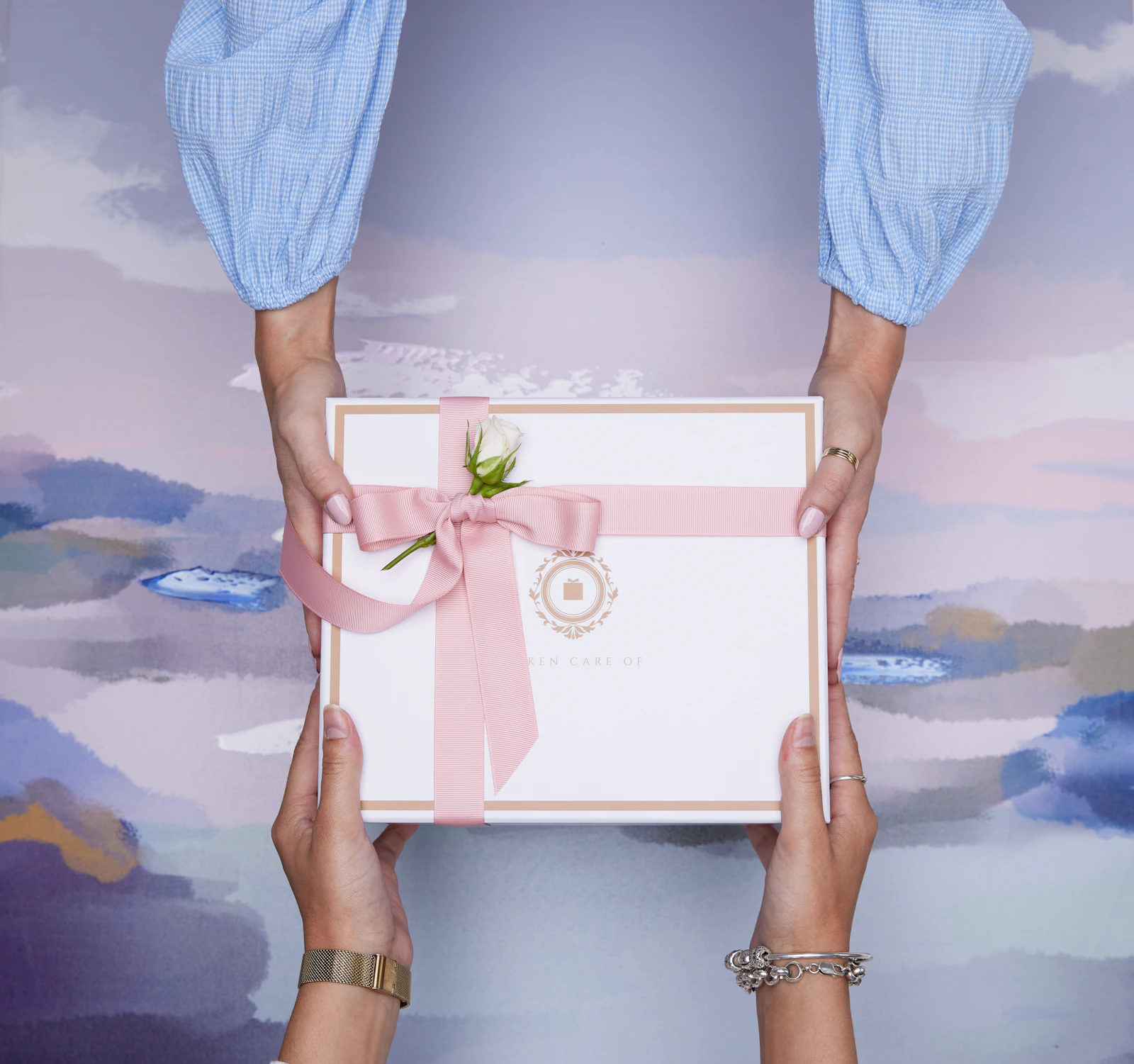 A pair of hands carefully exchanging a beautifully wrapped gift box