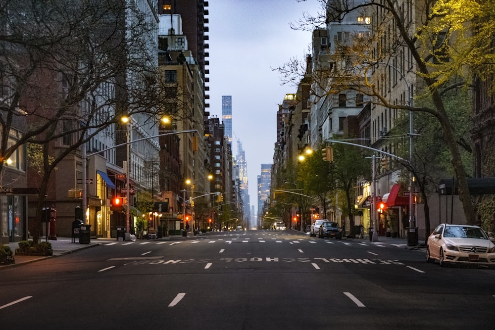 cars on road between high rise buildings during daytime