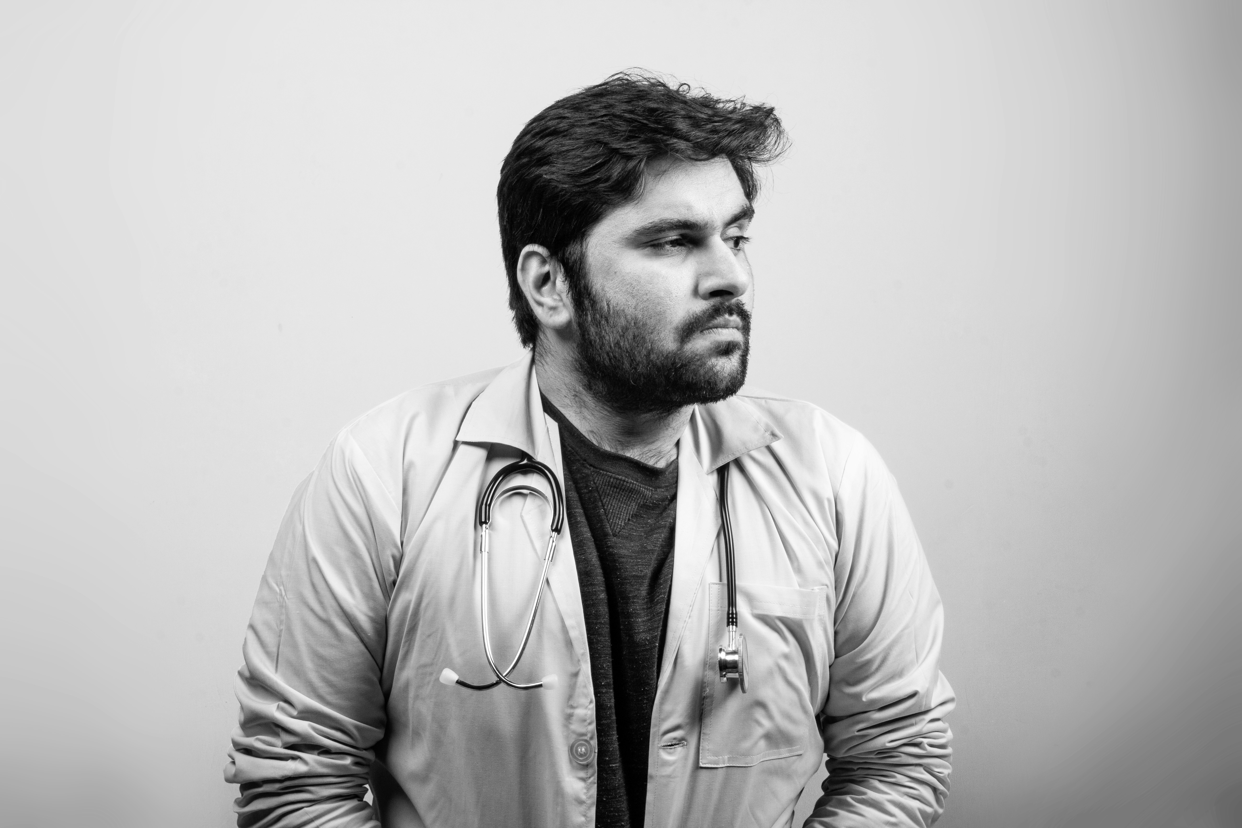 man in white button up shirt, A doctor looking at one side thinking - Black and White