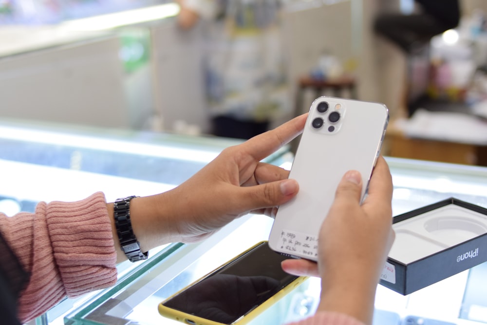 person holding white and black remote control