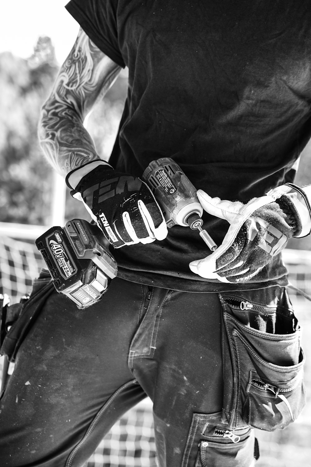 Ein Schwarz-Weiß-Foto eines Mannes, der ein Paar Handschuhe hält