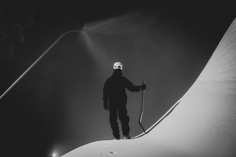Un hombre parado en la cima de una ladera cubierta de nieve