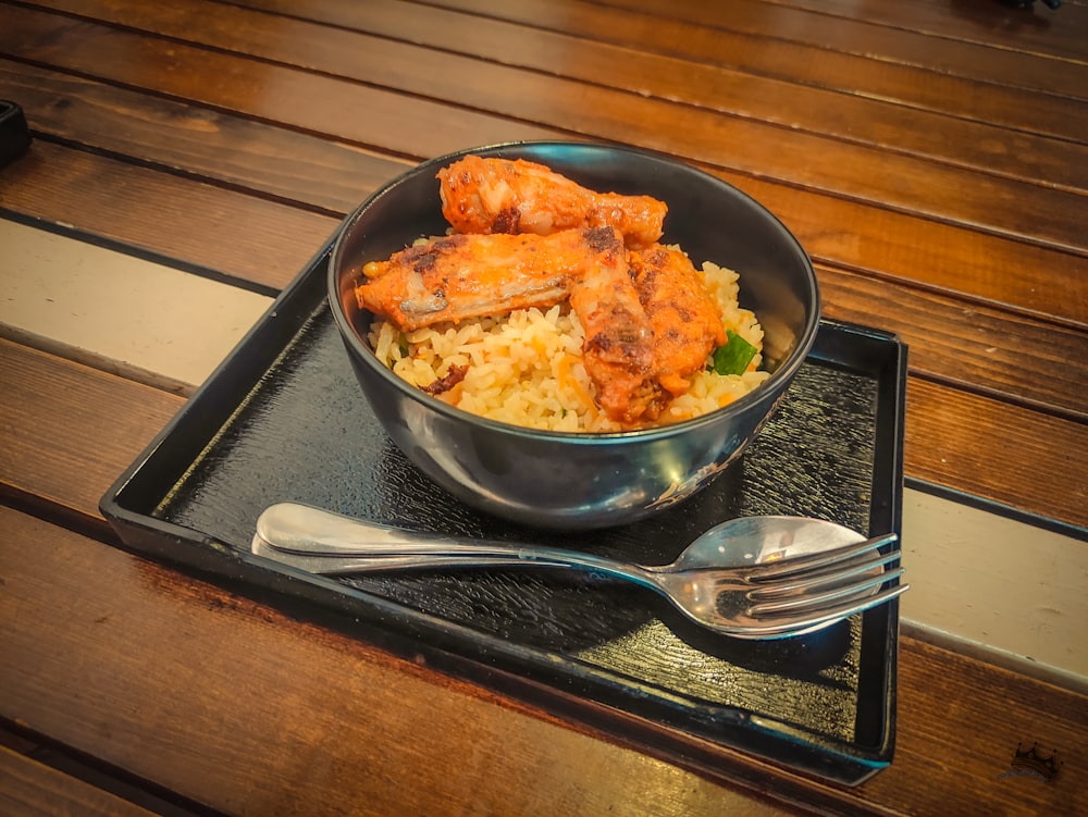 stainless steel spoon and fork on blue ceramic bowl