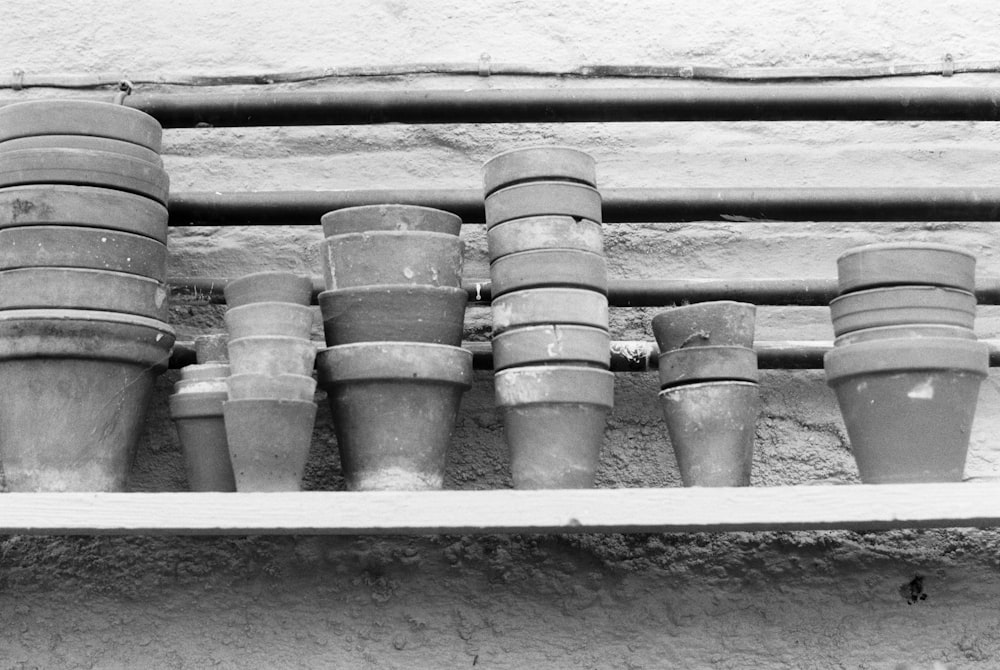 grayscale photo of plastic cups on wooden surface