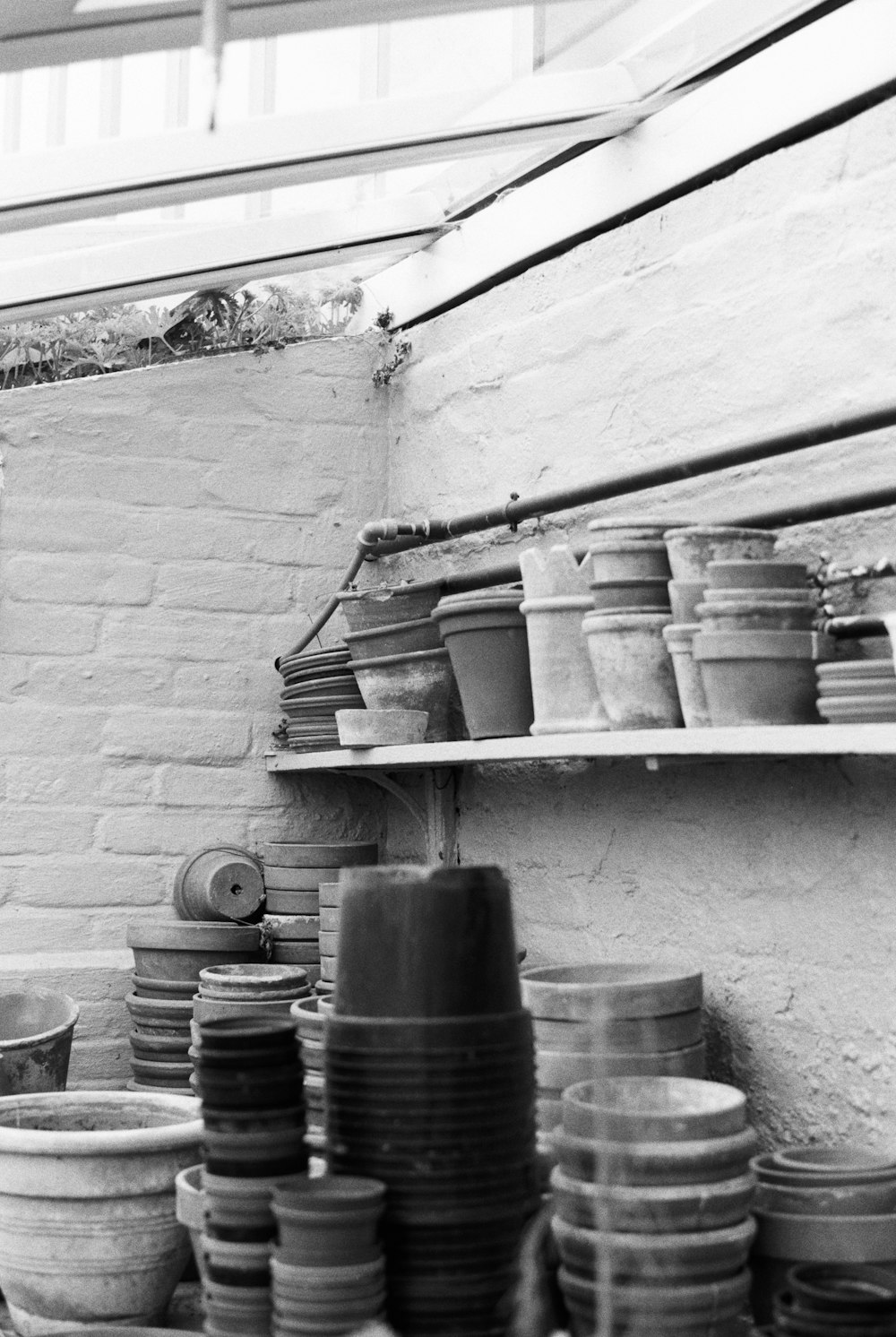 grayscale photo of plastic bucket on shelf