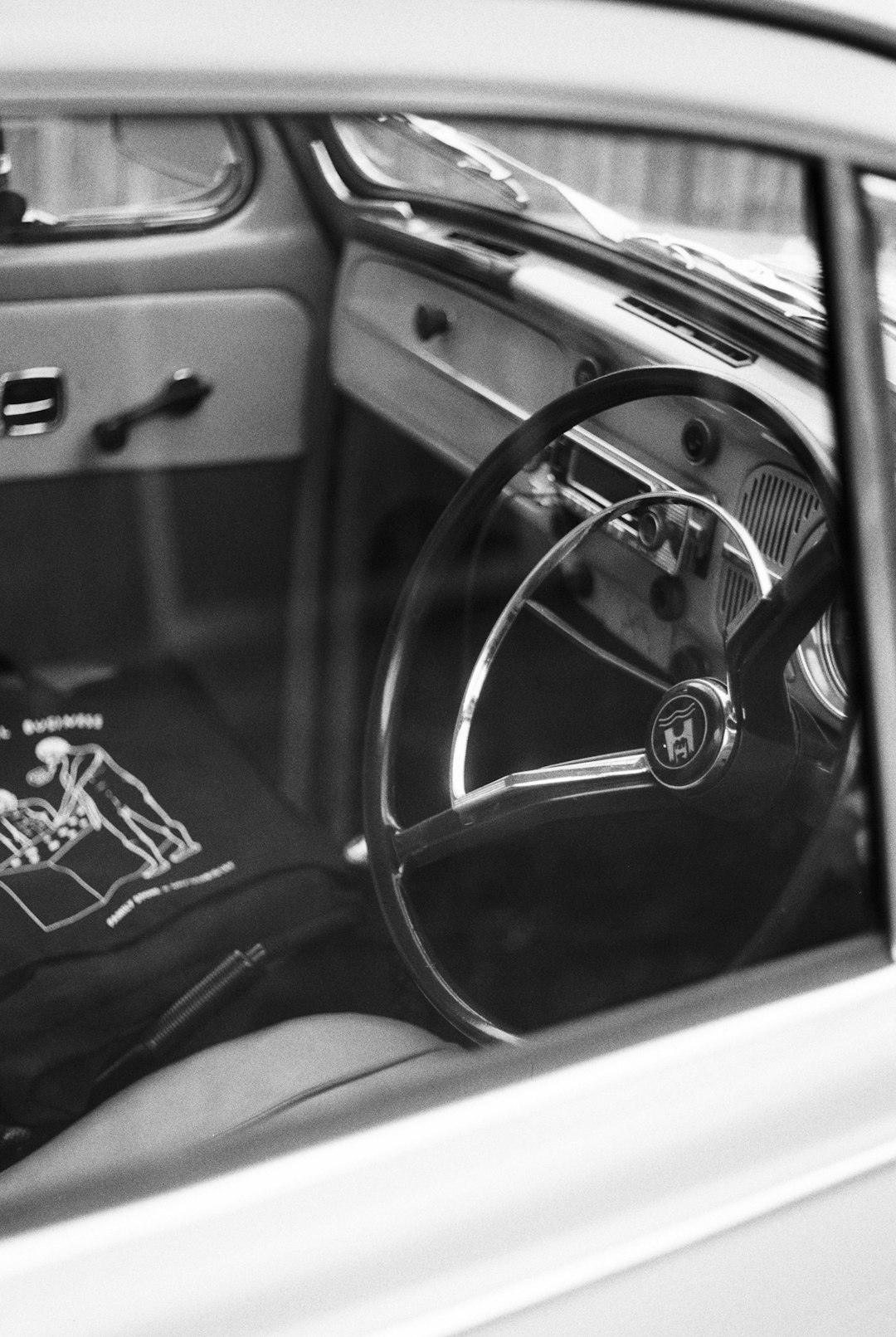 grayscale photo of car steering wheel