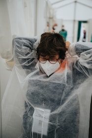 woman in white veil covering her face with white sheer textile