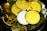 A collection of shiny cryptocurrency coins, including Bitcoin, Ethereum, and others, resting on a bed of green moss inside a transparent dish. The coins are gold and silver, reflecting light and creating a bright, luxurious appearance.