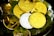 A collection of shiny cryptocurrency coins, including Bitcoin, Ethereum, and others, resting on a bed of green moss inside a transparent dish. The coins are gold and silver, reflecting light and creating a bright, luxurious appearance.